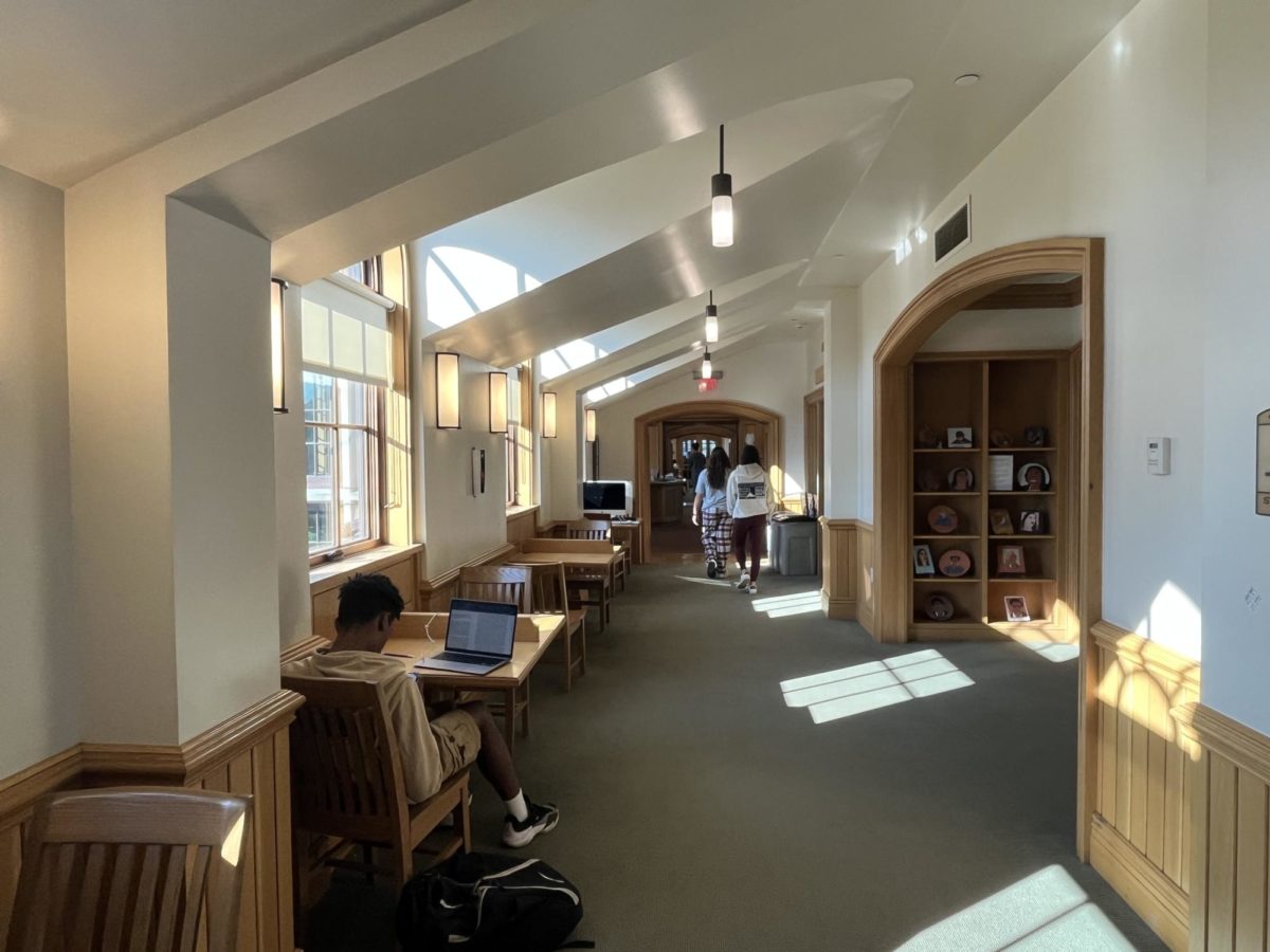9th graders Lily Hegener and Sophie Kim walk through the Sternberg Library. The Library provides computers and space for students to catch up on their work. This hallway connects the main Library and Computer Lab. 