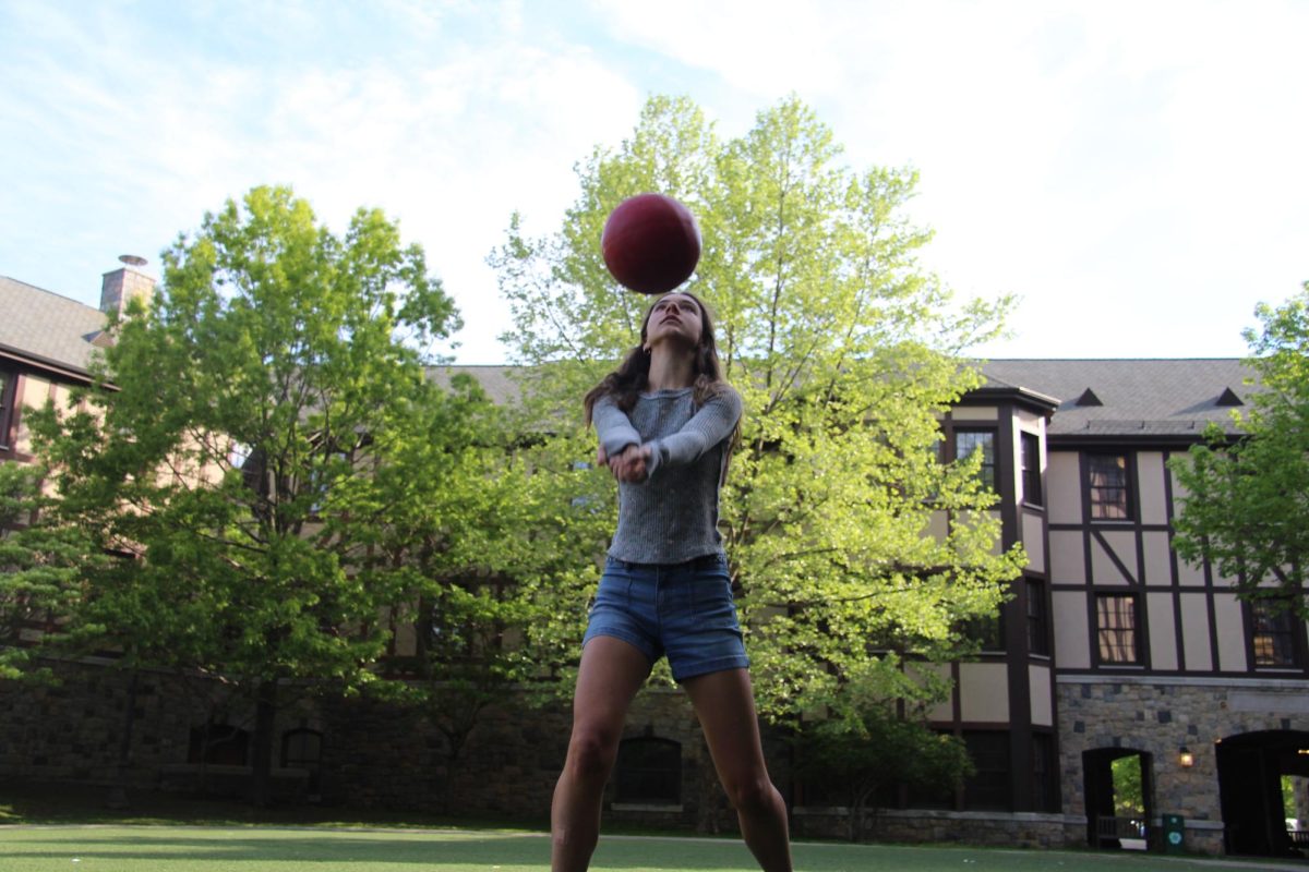 Ninth grader Charlotte Duffy plays volleyball on Akin Common. She and her friends come here to study, play, or even just to walk around and talk. The tree in the background is illuminated by the sun as the spring foliage starts to sprout at Hackley. 