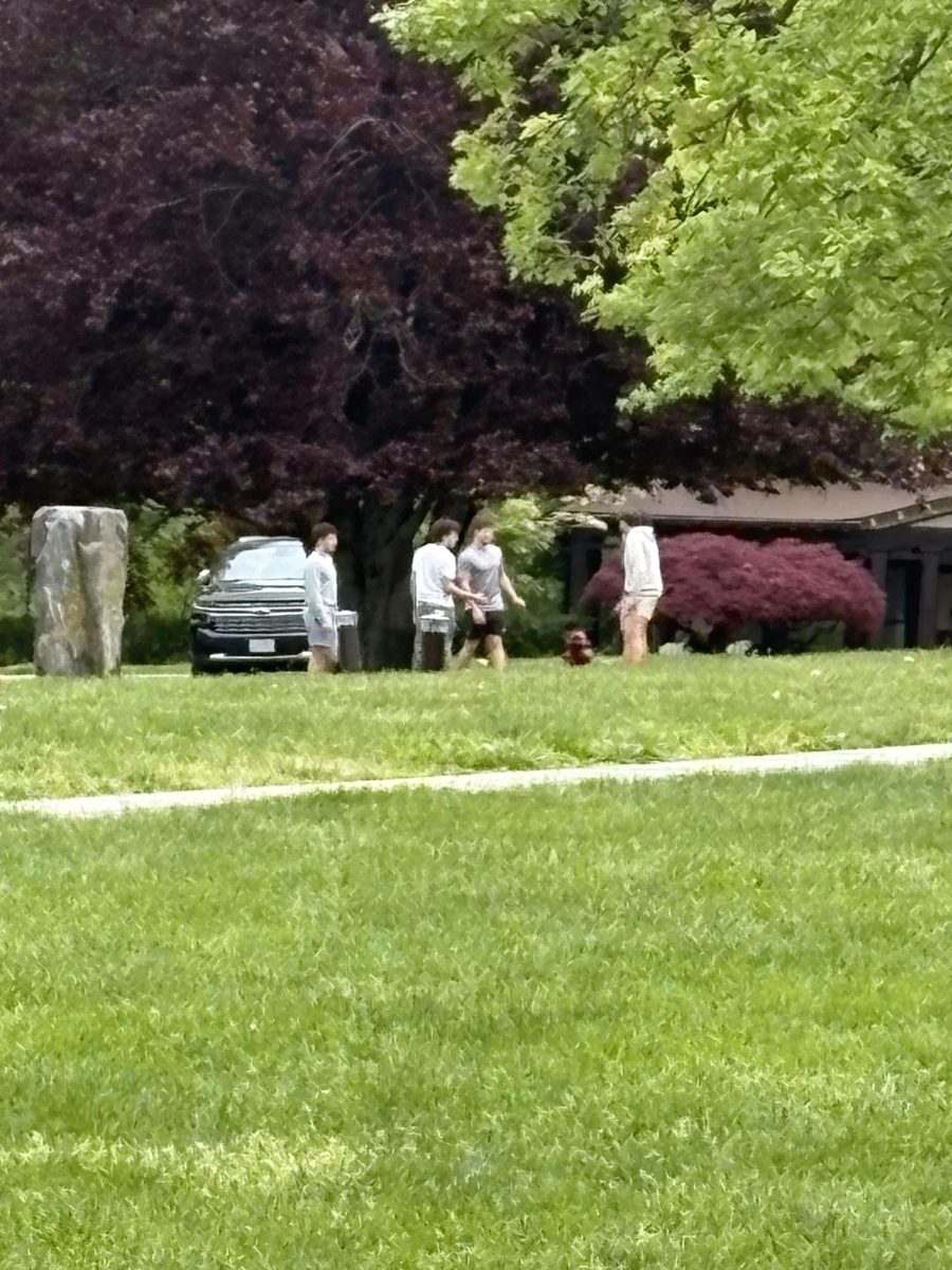 A group of upperclassmen play with a hacky sack on the Quad